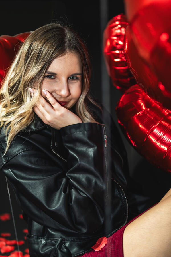 Portret Studio Walentynki Zbliżenie na uśmiechniętą kobietę podczas walentynkowej sesji zdjęciowej z czerwonymi balonami.